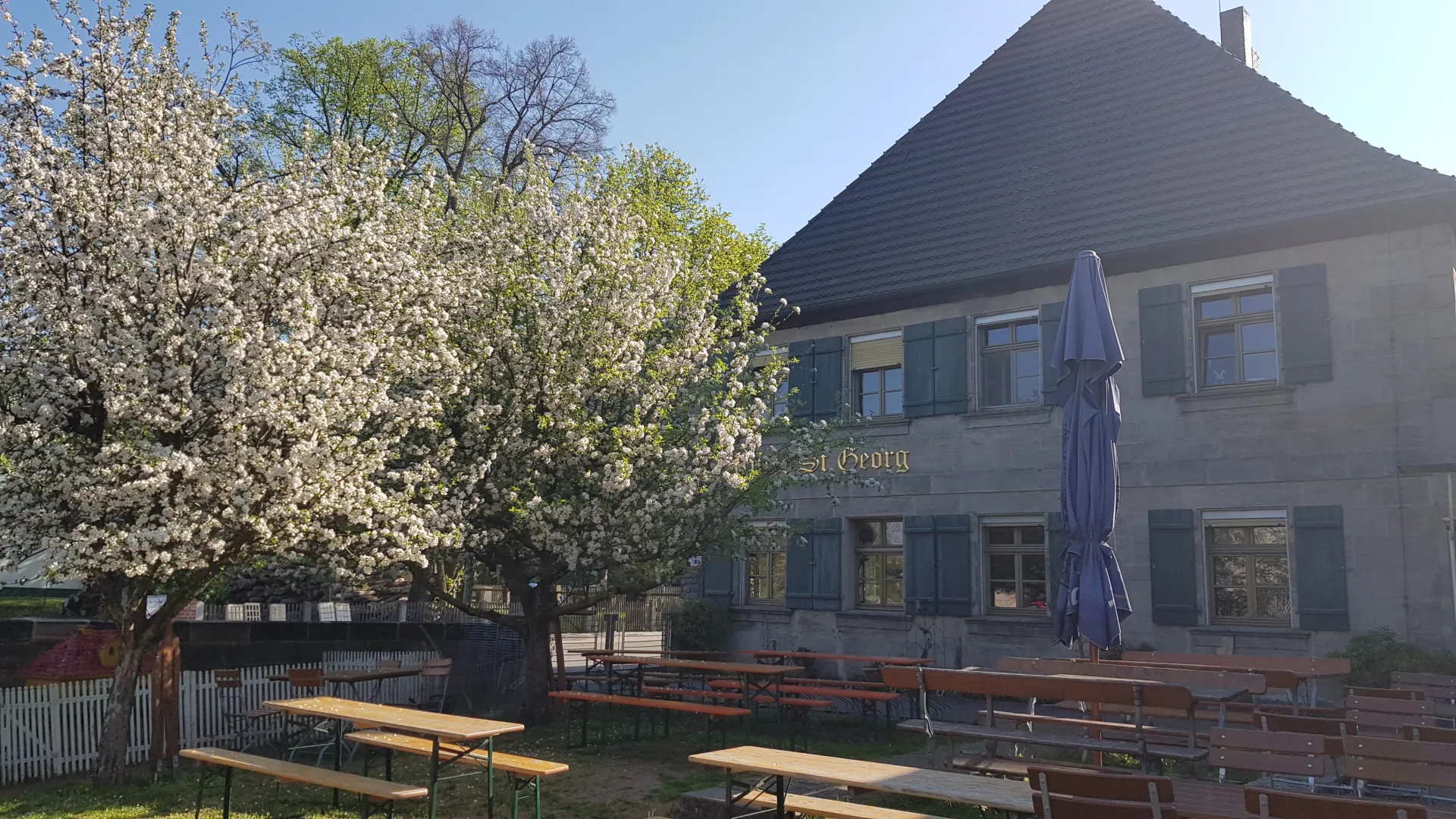 Biergarten des Ritter St. Georg im Frühling mit blühendem Baum