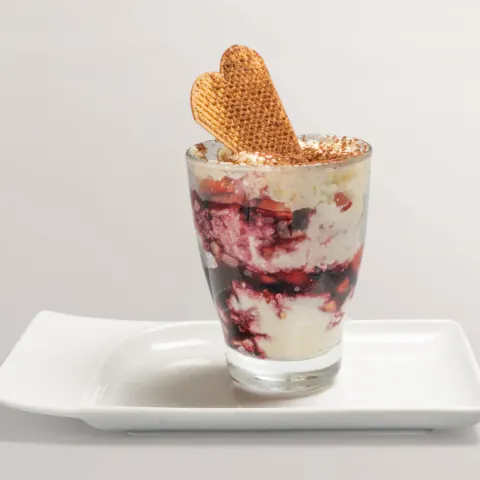 Erdbeer-Tiramisu im Glas mit Waffelherz und Kakao bestäubt