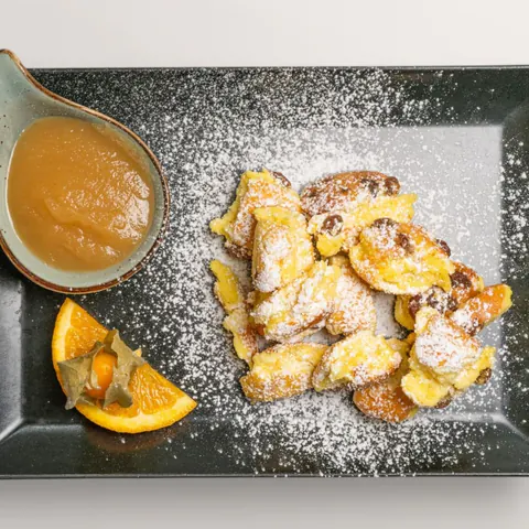 Kaiserschmarrn mit Puderzucker, Apfelmus und frischer Orange – klassisches Dessert im Gasthof Ritter St. Georg Erlangen