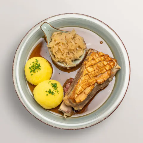 Fränkisches Schäufele mit knuspriger Kruste, Kartoffelklößen und Sauerkraut – traditionelles Gericht im Gasthof Ritter St. Georg Erlangen