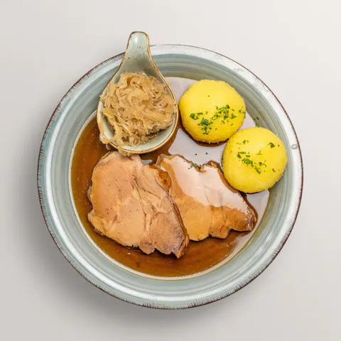 Fränkischer Schweinebraten mit Kartoffelklößen, Sauerkraut und dunkler Bratensauce – traditionelles Gericht im Gasthof Ritter St. Georg Erlangen